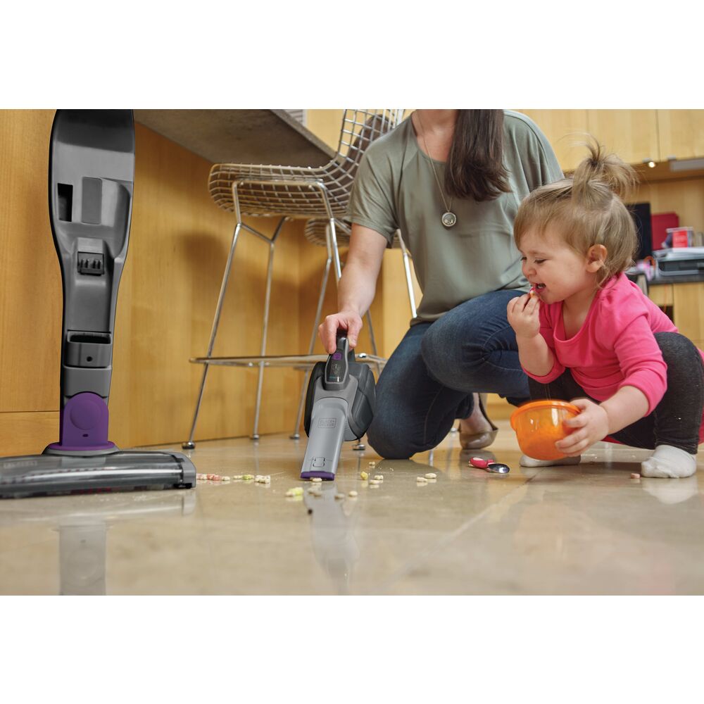 Black-and-decker POWERSERIES 2 in 1 Cordless Stick Vacuum being used to clean mess made by a toddler on the floor.
