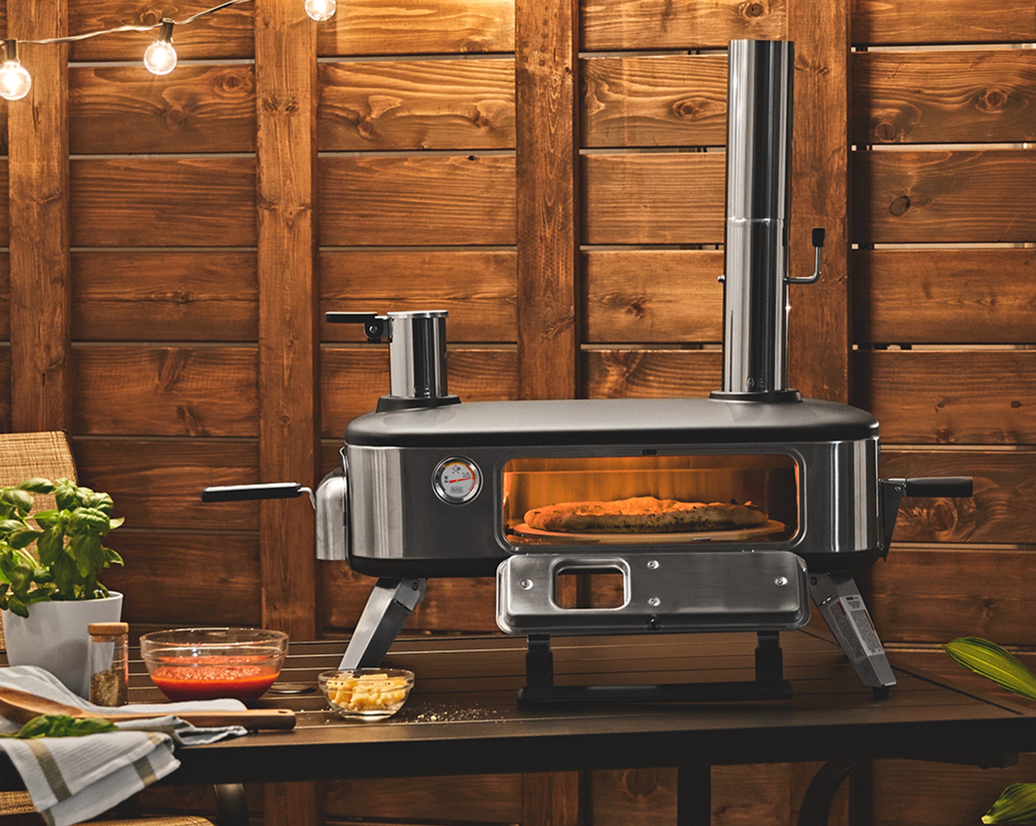 Pizza cooking inside of the Black-and-decker vera™ 12 in. pizza oven with the door open