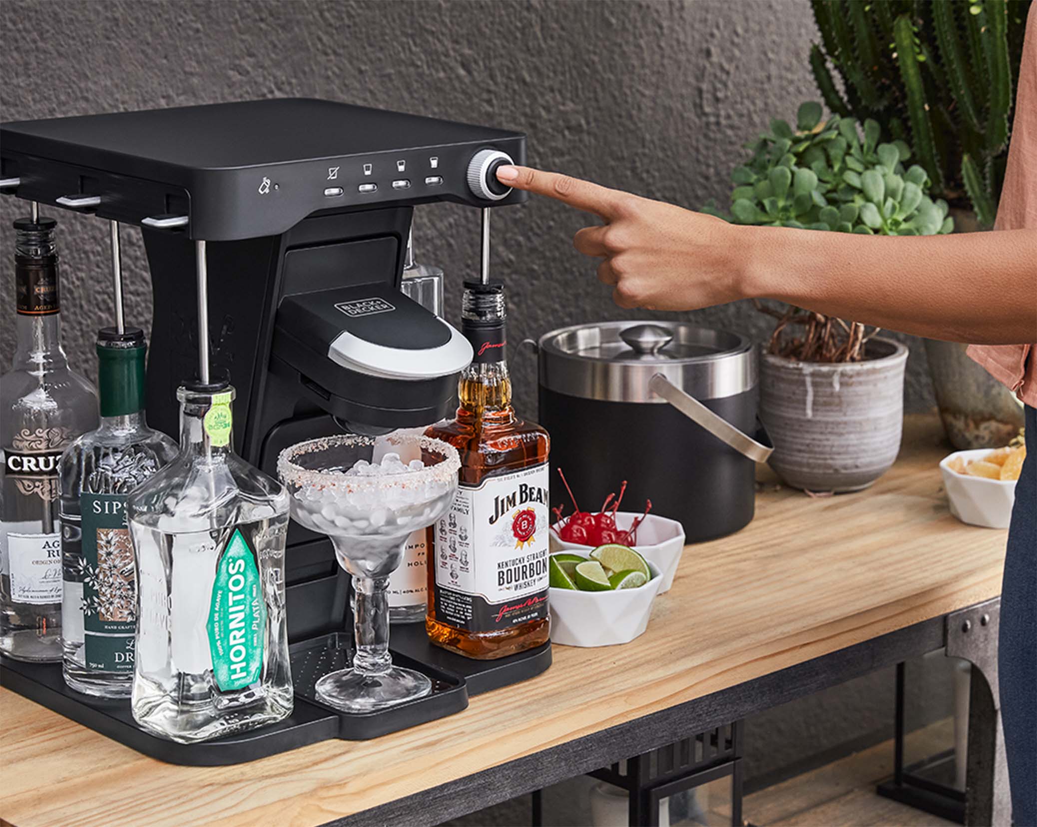 woman, on the patio, pressing the mix button on the bev by Black-and-decker™ cocktail maker to make a margarita