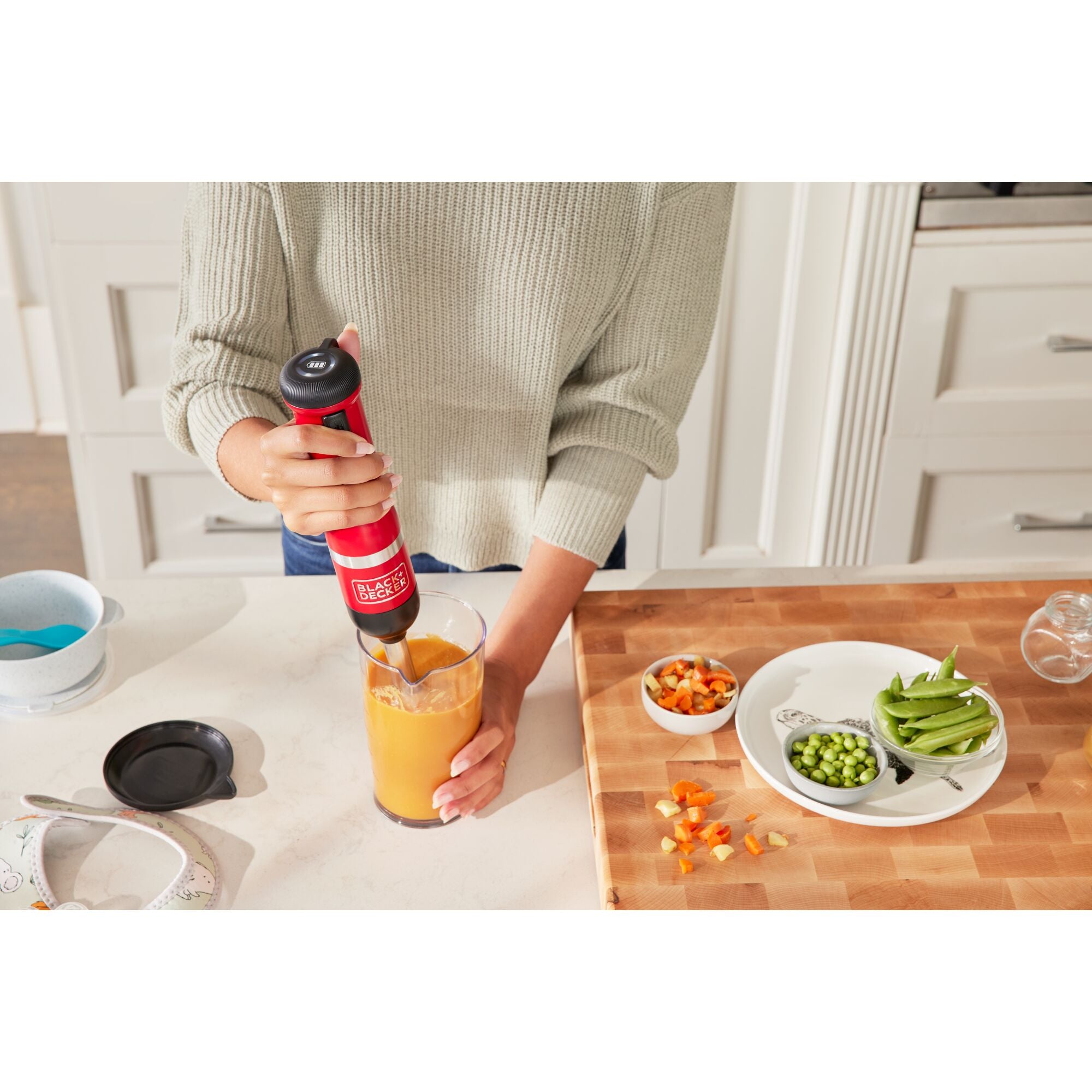 Front view of the red, Black-and-decker kitchen wand with immersion blender attached